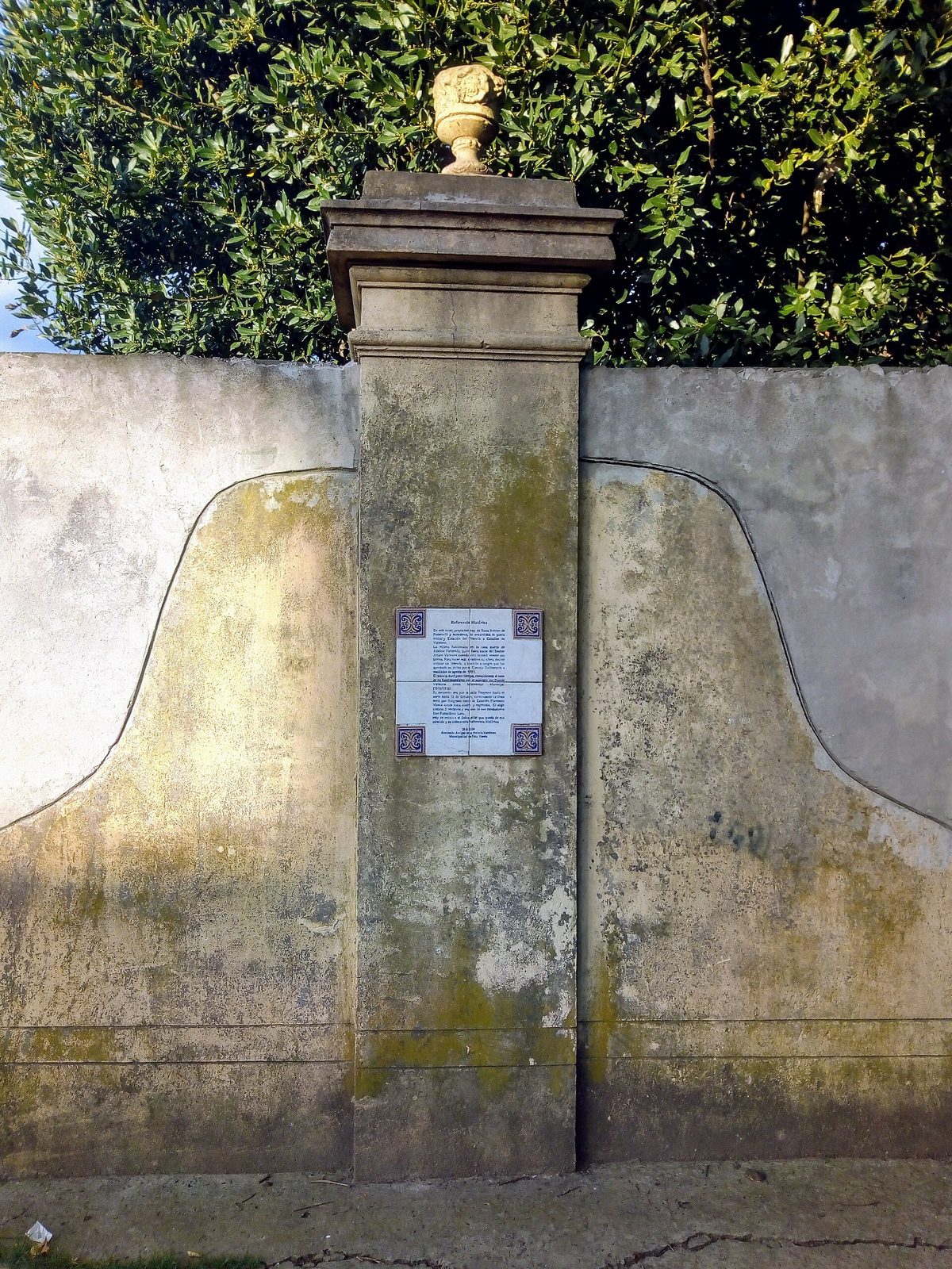 Portón antiguo con una placa que recuerda el paso del tranvía por Villa Vatteone