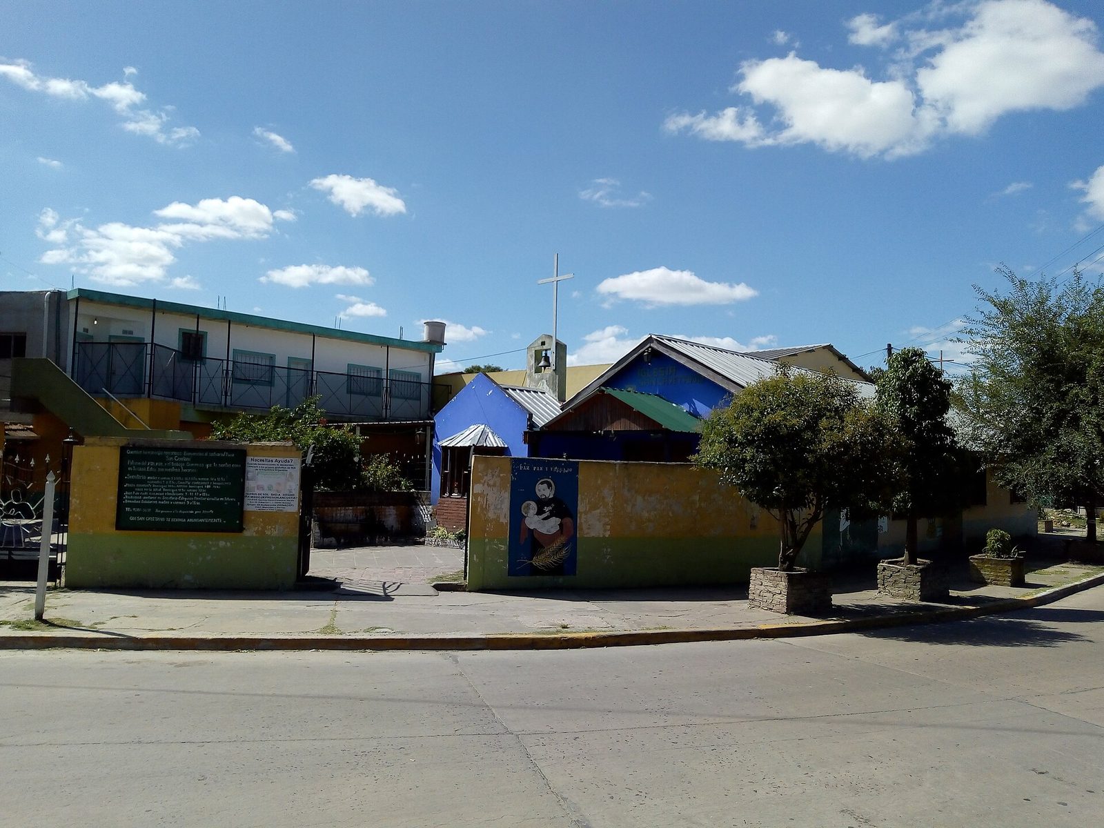 Fachada del santuario de San Cayetano con murales de colores en una esquina del partido